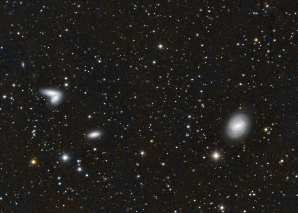 Messier 58 and the Siamese Twins
M58 is a barred spiral galaxy about 62 million light-years away in the constellation Virgo.  The Siamese Twins, NGC 4567 and 4568, are colliding spiral galaxies about 60 million light-years away, in the early stages of merging; they are also nicknamed the Butterfly Galaxies.
