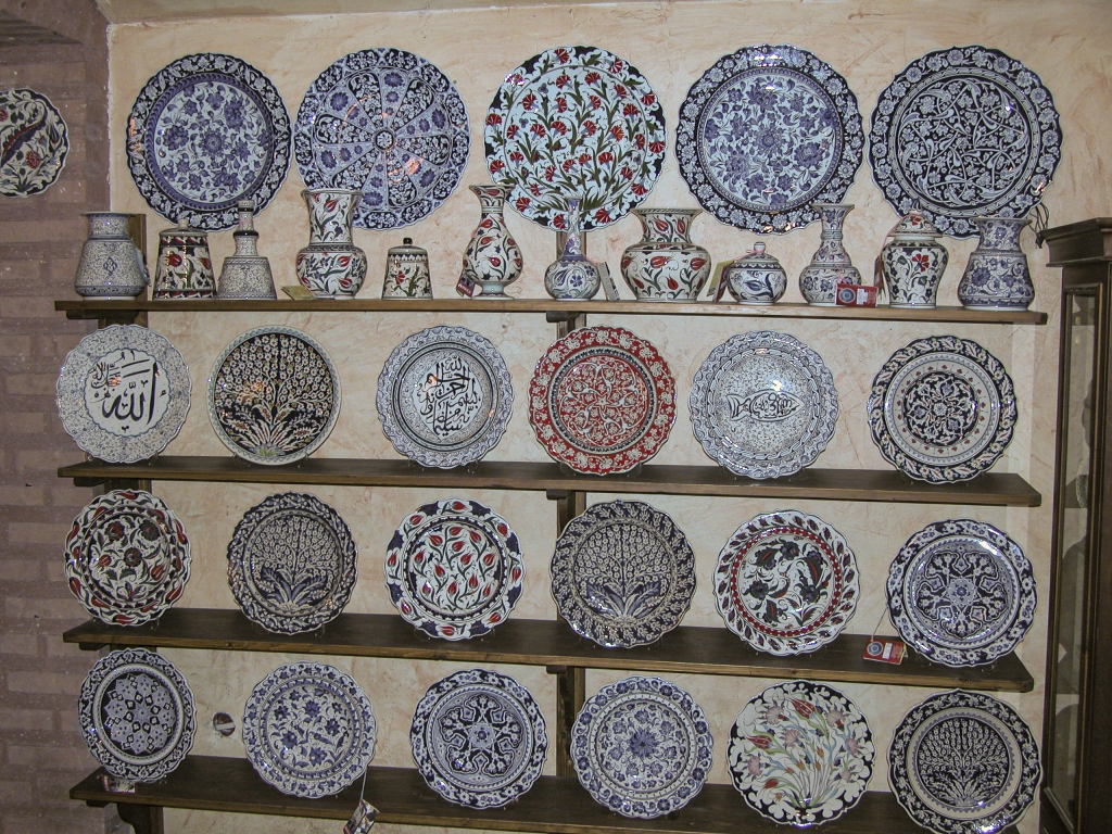 A Shelf Full of Dinnerware
Plates on the lower shelves, condiment vessels on the top shelf, and platters hanging on the wall above.
