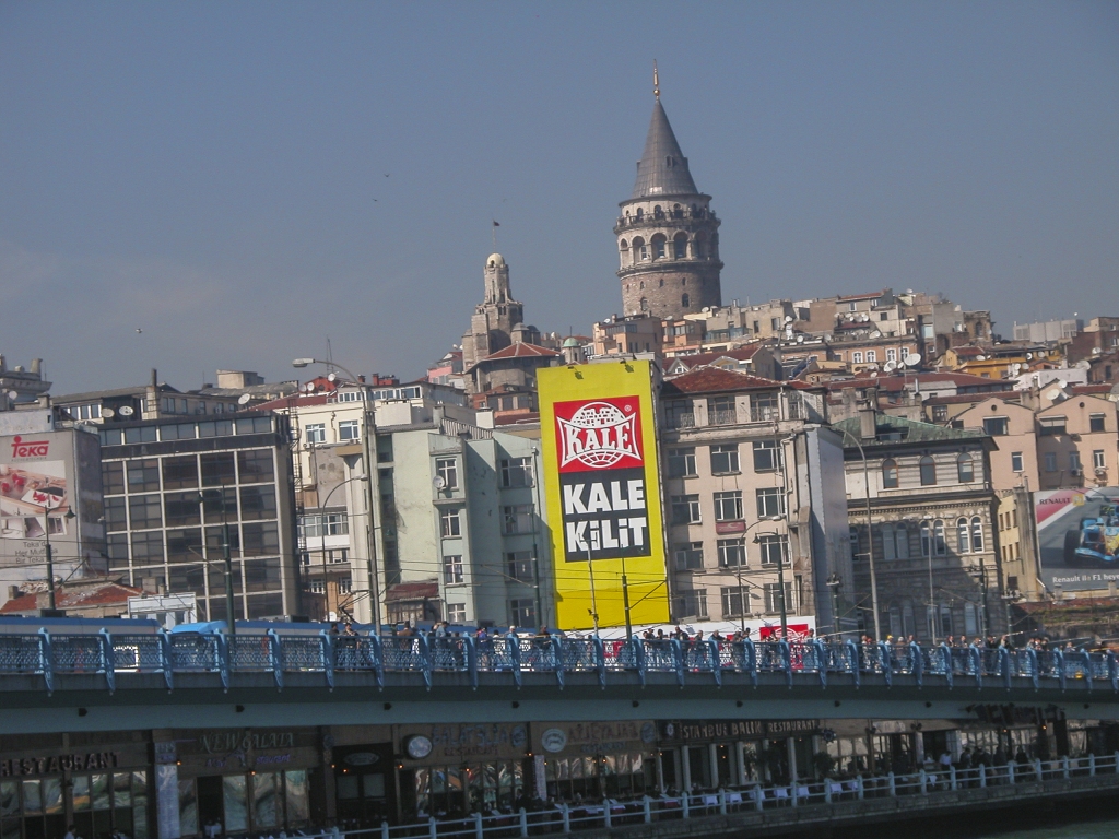 Galata Bridge
Fishermen line the railings of this 19th-century bridge, and fish-sandwich restaurants occupy the lower level.  As for the billboard, I guess the Turks must eat a lot of Kale.
