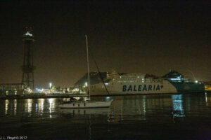 Cruise ship docked near the Torre Sant Sebastià, with sailboat crossing